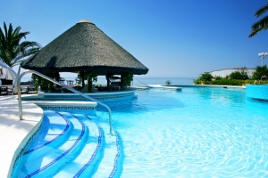 Tiki hut and bar by swimming pool of luxury hotel